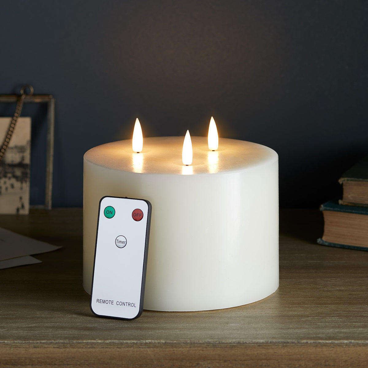 Dreidochtige LED-Kerze mit Fernbedienung auf dunklem Holztisch