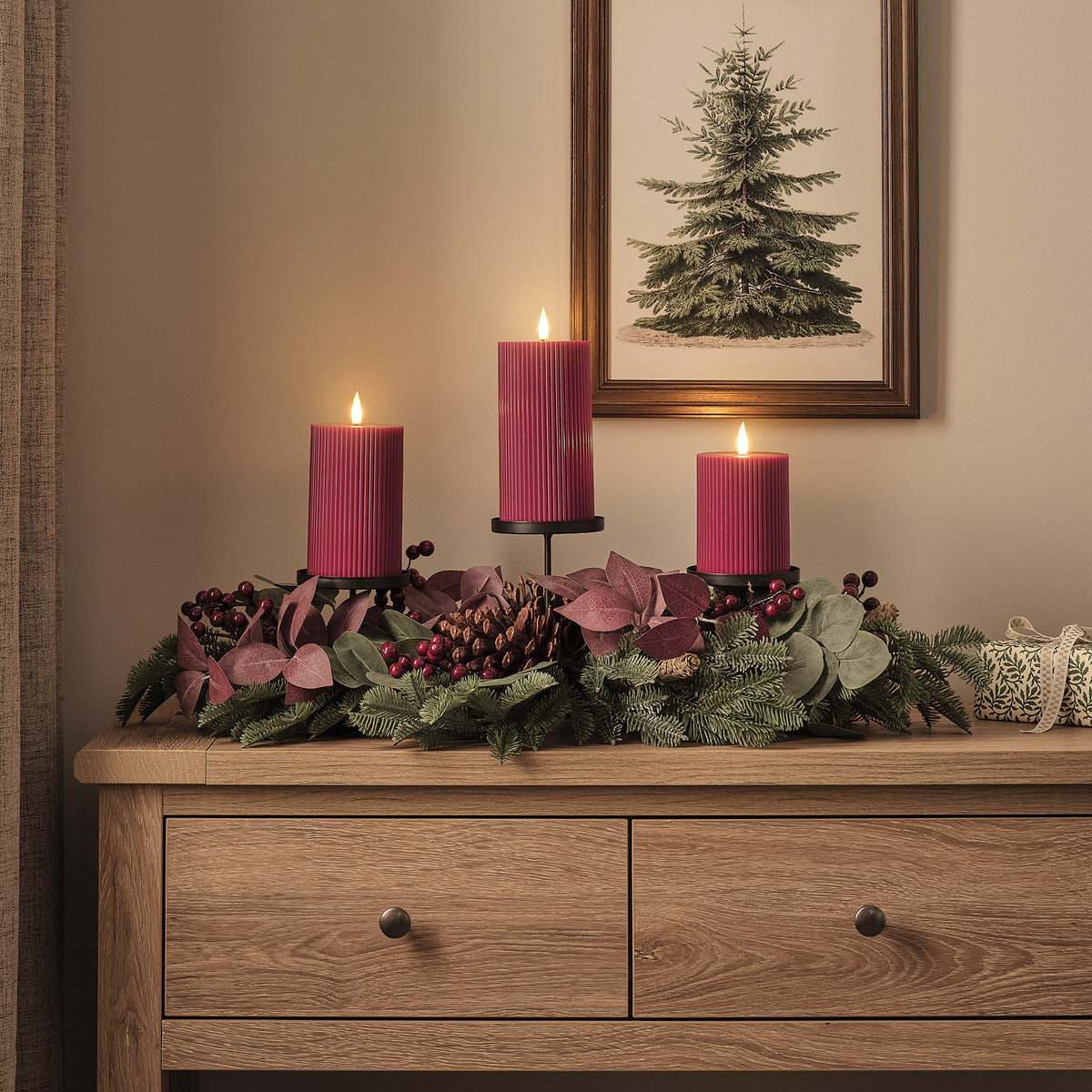 Weihnachtliches Tischgesteck mit drei pflaumenfarbenen LED-Stumpenkerzen auf Holzkommode