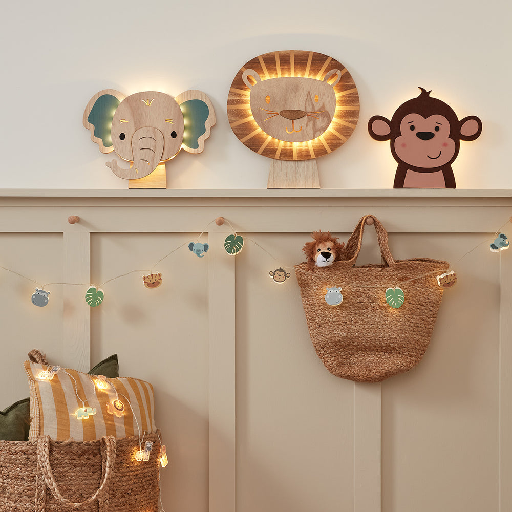Kinderzimmer mit Safari-Wandlampen in Elefanten-, Löwen- und Affenform sowie zwei Safari-Lichterketten mit Tier- und Blattmotiven