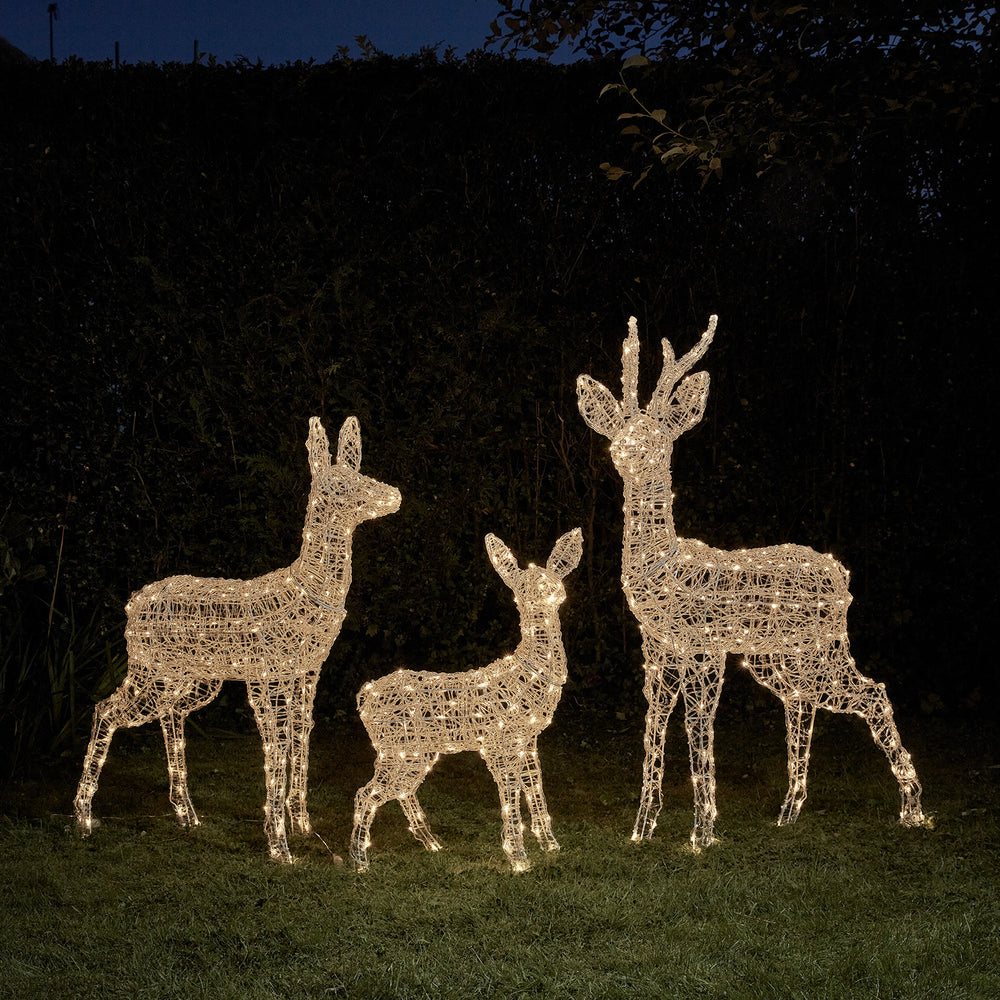 Drei beleuchtete Rentierfiguren aus Acryl und Metallrahmen in warmweißem Licht im Garten bei Nacht