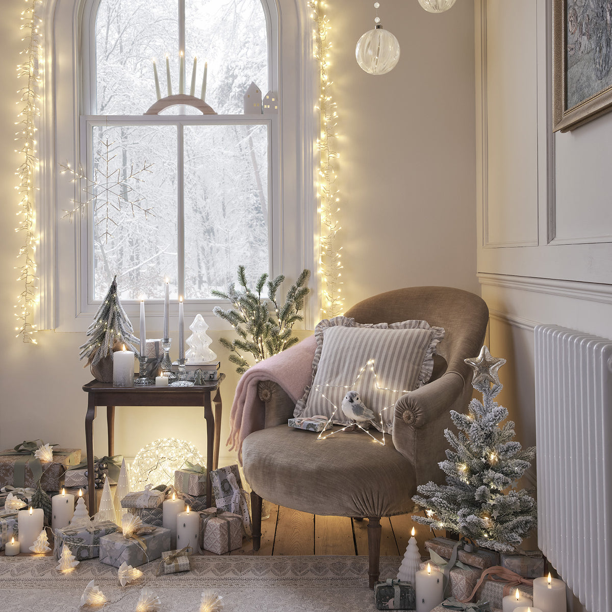 Gemütliche Ecke mit Sessel, LED Stabkerzen, Weihnachtsbaum und vielen Geschenken im Raum