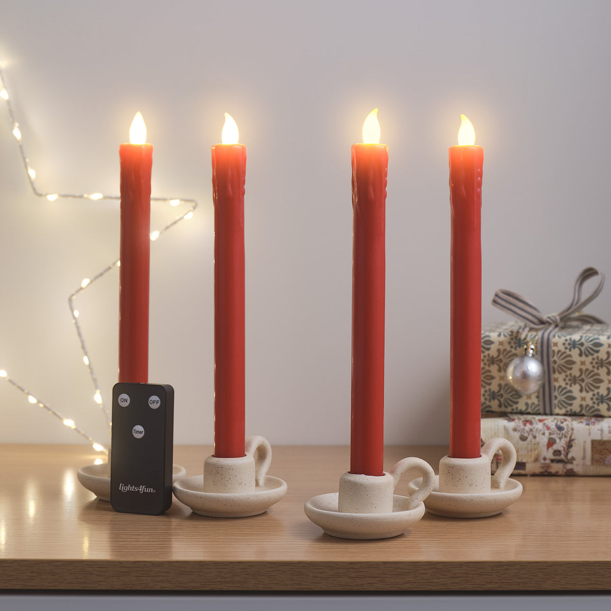 Vier rote LED Tafelkerzen in weißen Kerzenhaltern mit Fernbedienung und Geschenkpaketen