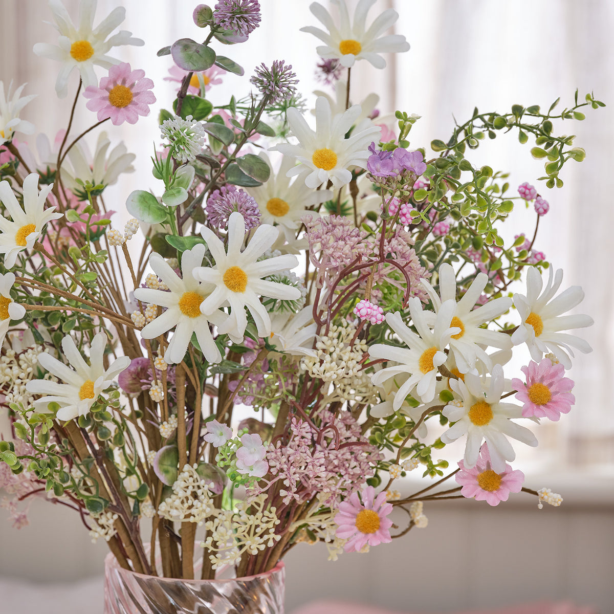 Detailaufnahme von künstlichen weißen und rosa Gänseblümchen mit grünem Blattwerk