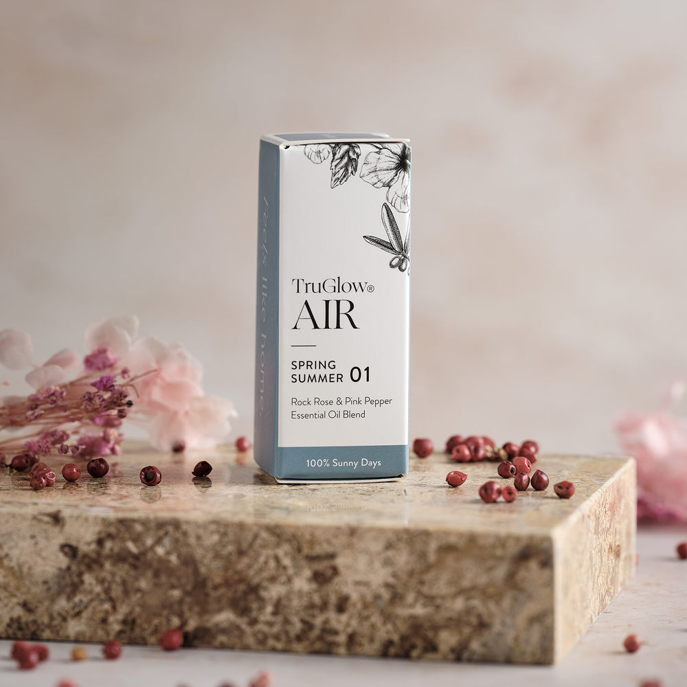 Verpackung des TruGlow AIR Duftöls Zistrose & Rosa Pfeffer mit floralen Illustrationen auf Steinplatte
