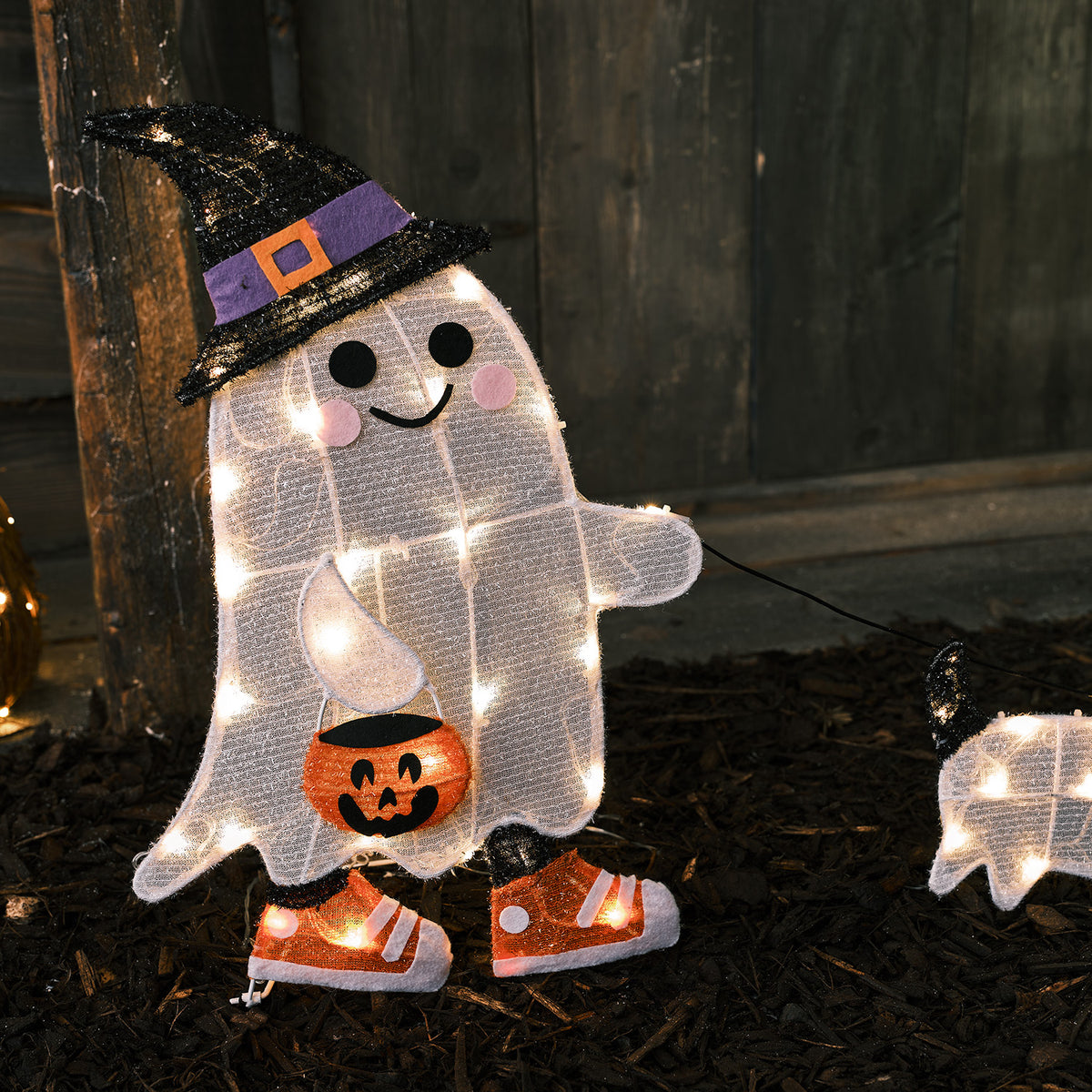 Nahaufnahme leuchtender 2D LED Figur Geist mit Hexenhut und Hund im Dunkeln