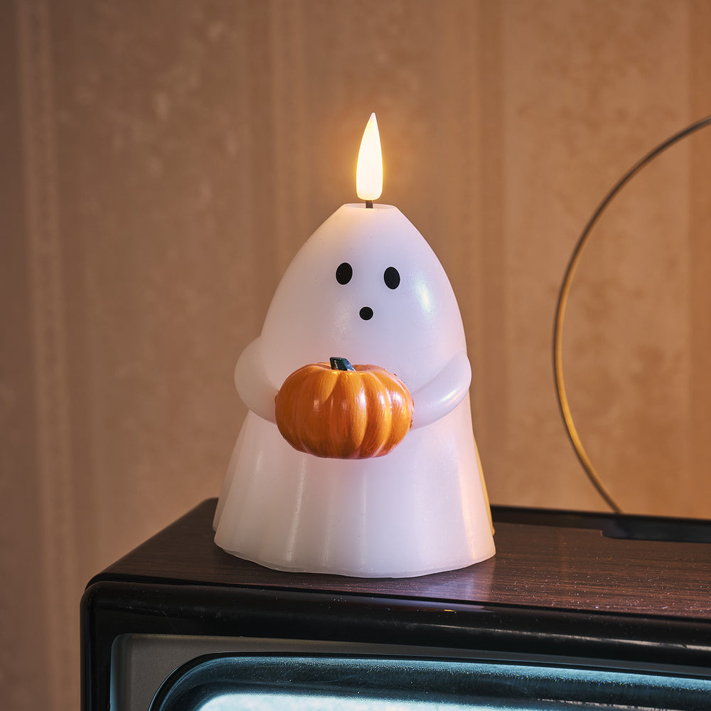 Nahaufnahme der TruGlow LED Geist-Kerze mit leuchtender Flamme und orangefarbenem Kürbis