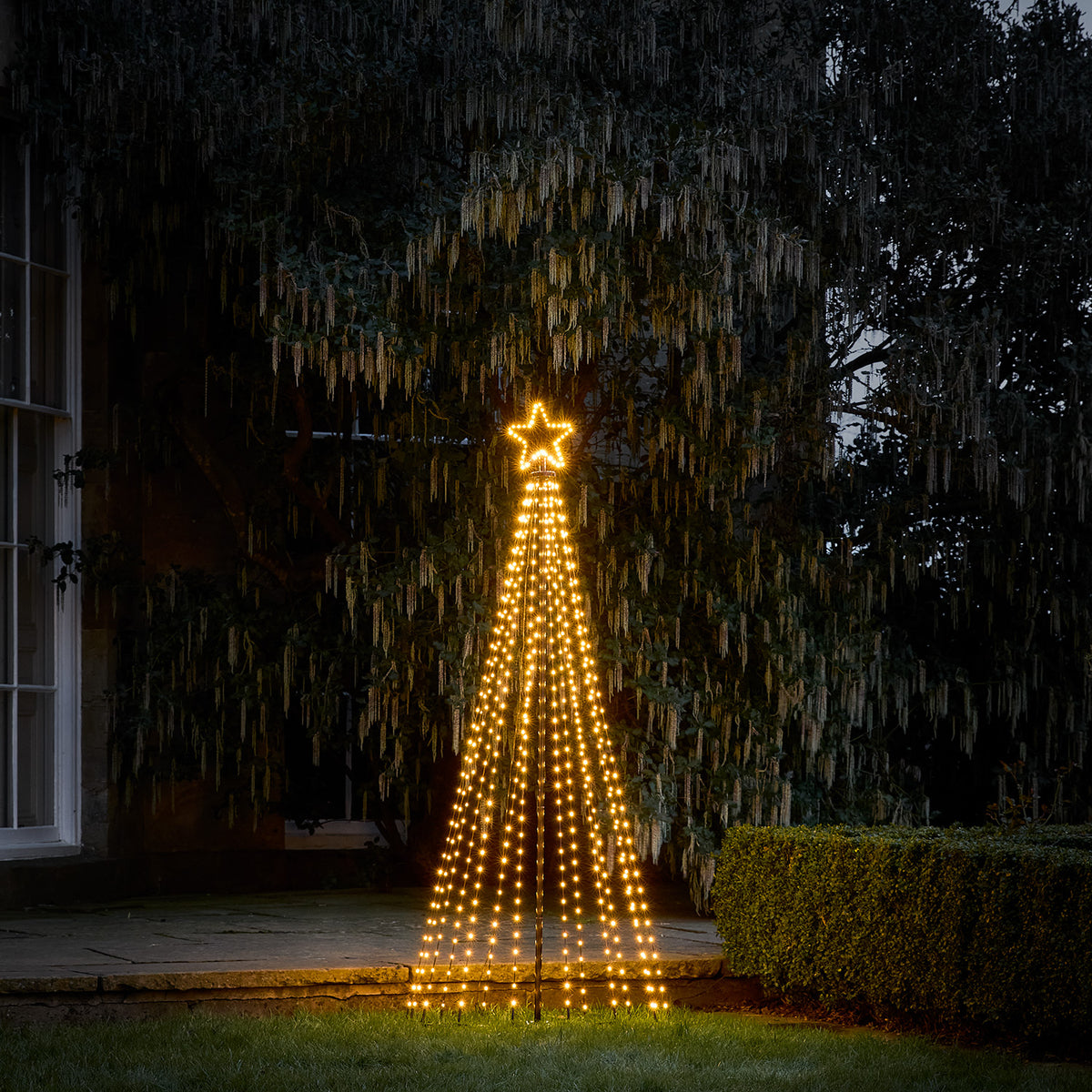 1,8 Meter hoher LED-Weihnachtsbaum mit warmweißen Lichtern und leuchtendem Stern im Garten bei Nacht