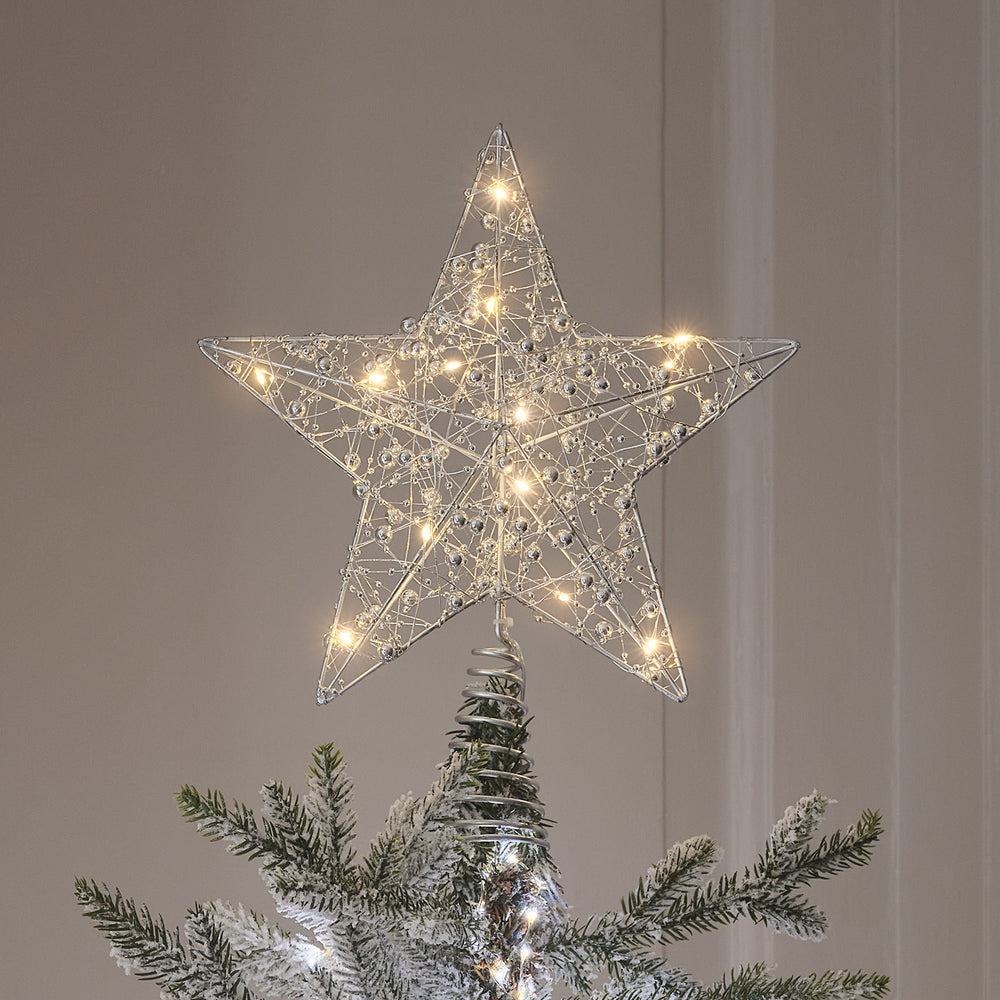 Nahaufnahme LED-Stern Weihnachtsbaumspitze mit silberfarbenem Draht und warmweißen LEDs