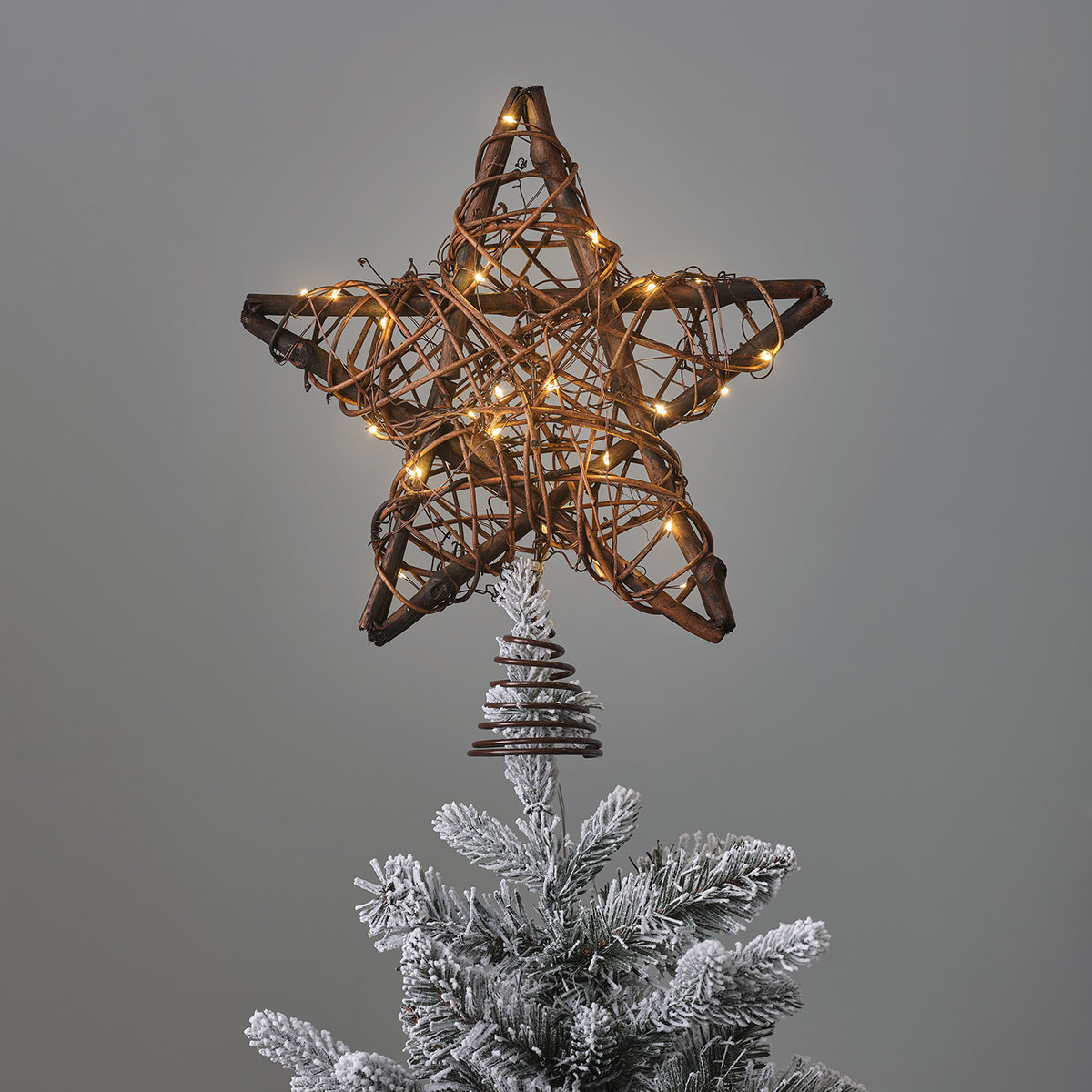 LED Weihnachtsbaumspitze Stern aus Rattan mit warmweißen Mikro-LEDs beleuchtet auf Tannenspitze