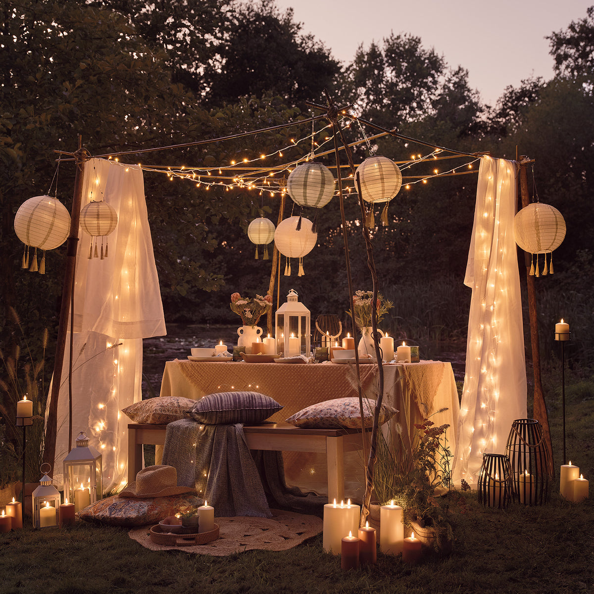 Abendliche Gartenparty mit weißen Laternen, Lichterketten und Dekoration