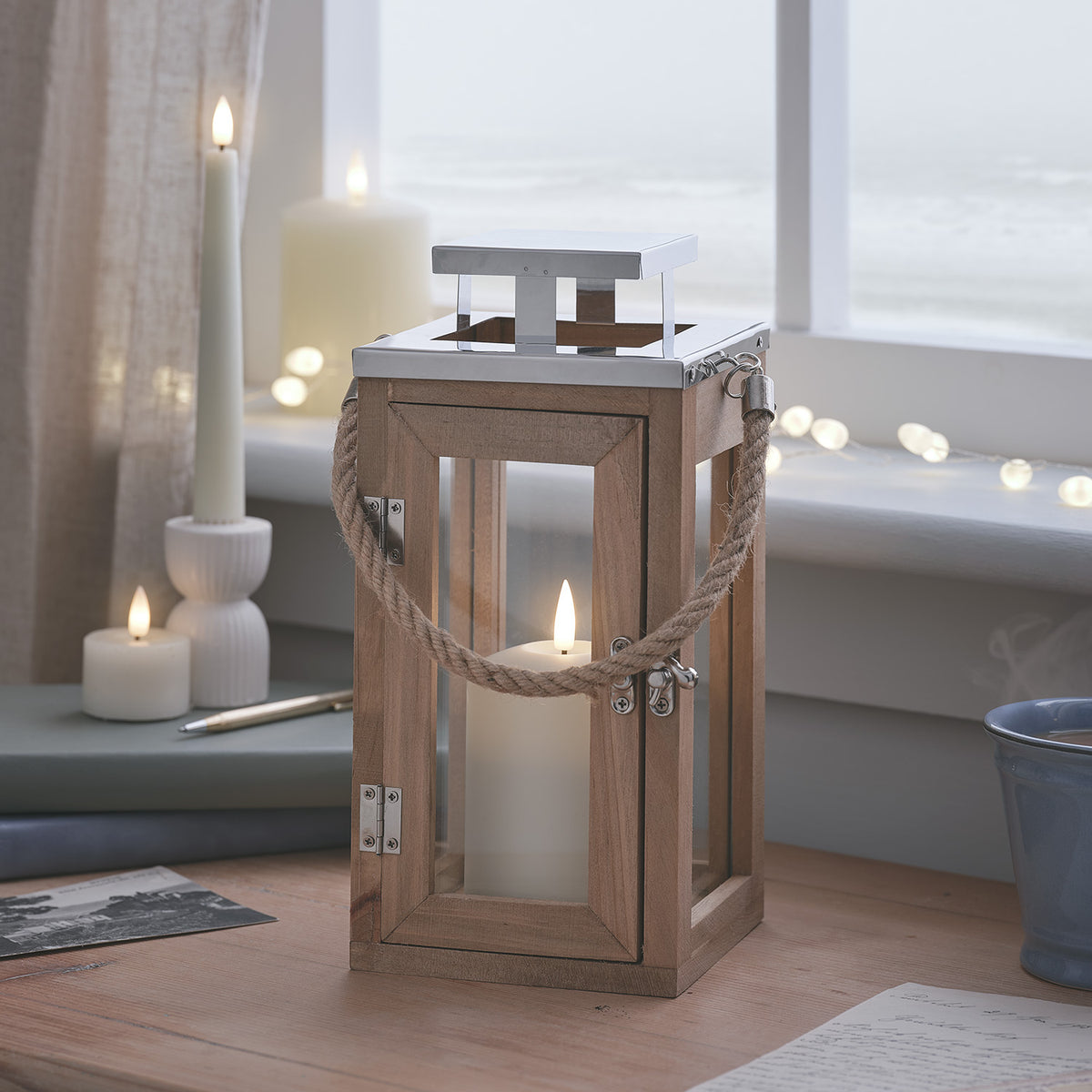 Salcombe LED-Laterne warmweiß leuchtend auf Fensterbank mit Kerzen und Tasse