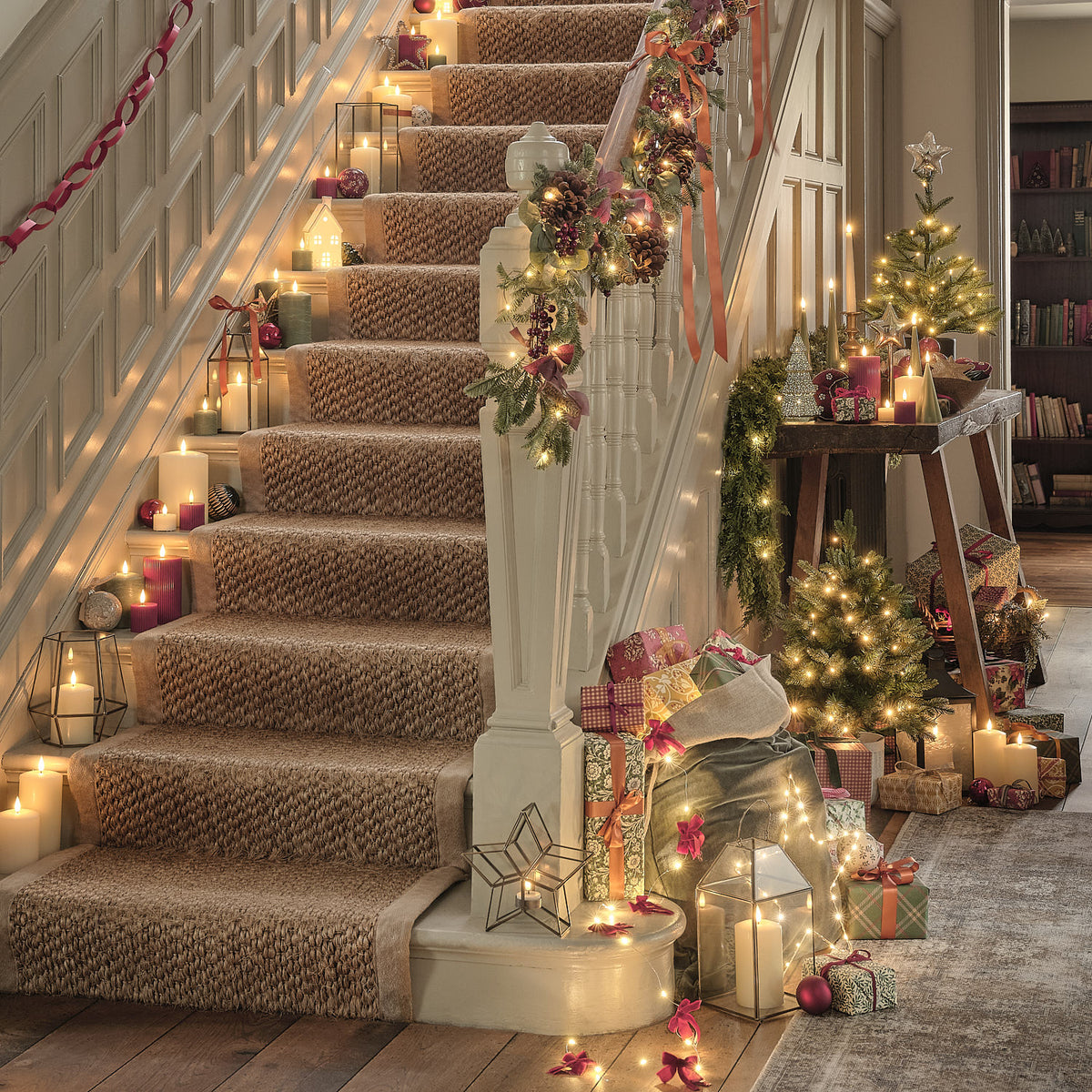 Weihnachtlich dekorierte Treppe mit LED-Laternen, Geschenken, Lichterketten und Kerzen