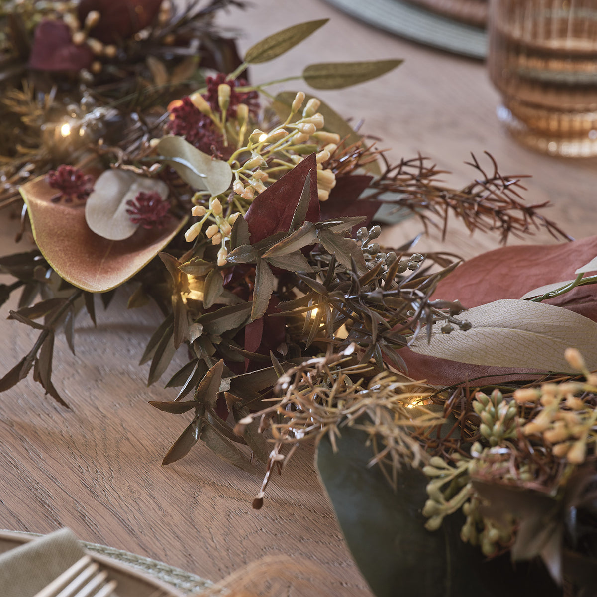 Detailaufnahme der herbstlichen Girlande mit warmweißen LEDs und verschiedenen Blättern