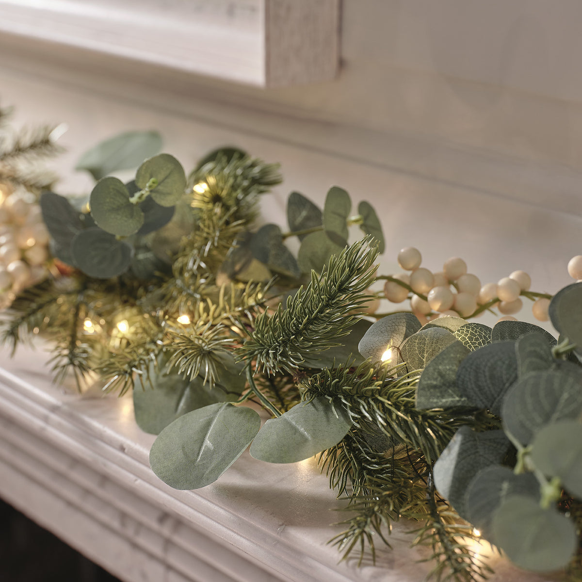 Nahaufnahme der Weihnachtsgirlande mit warmweißen LED-Lichtern und Eukalyptusblättern
