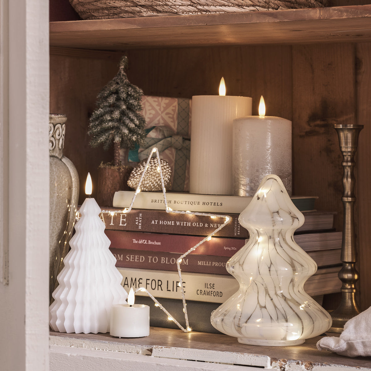Regal mit Weihnachtsdeko: LED Glas Tannenbaum, weiße Kerzen, Bücher und Lichterkette