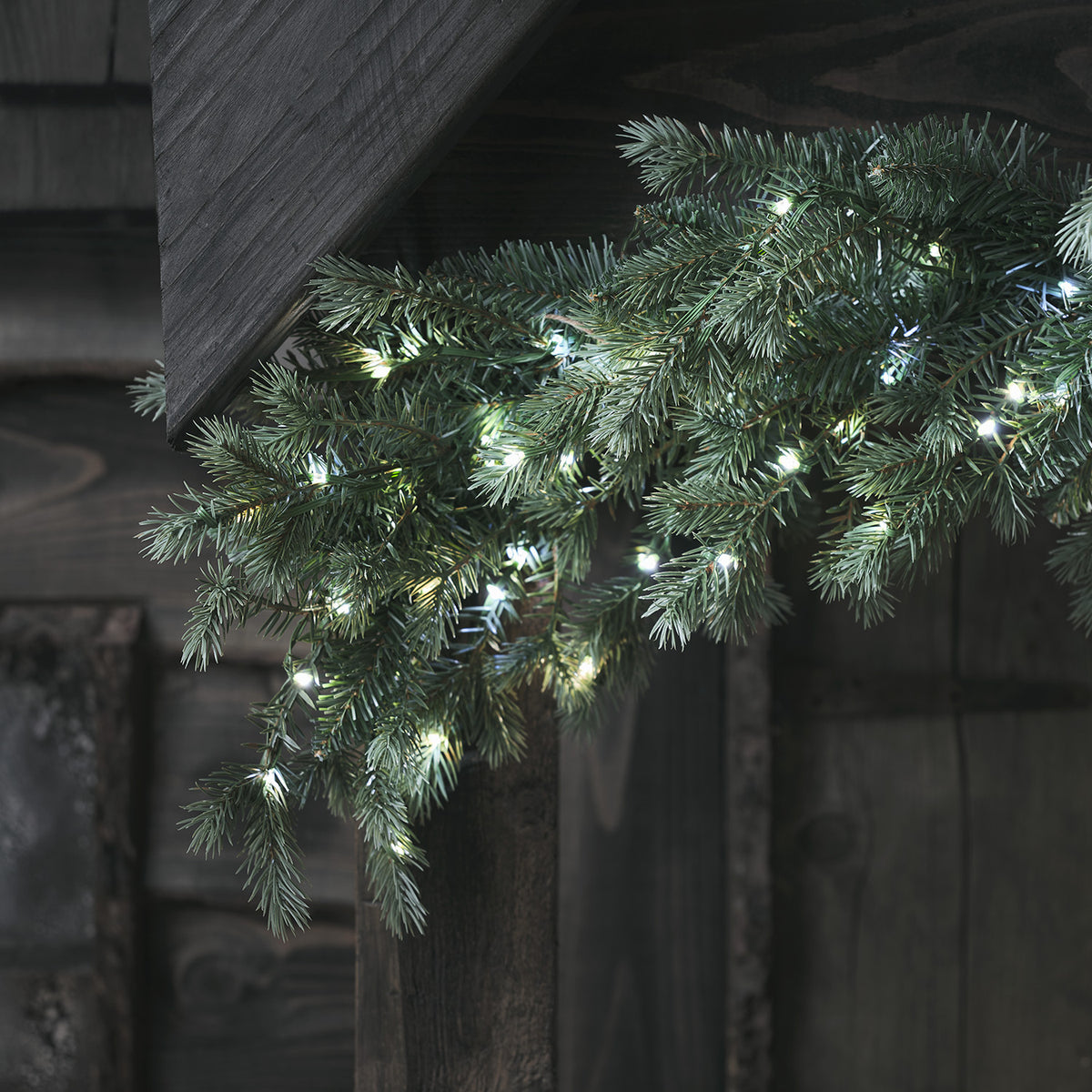 Tannengirlande mit zweifarbigen LEDs in Weiß und Warmweiß an Holz befestigt