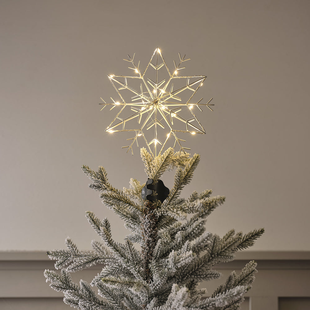 Weiße LED Metall Schneeflocke als Weihnachtsbaumspitze beleuchtet auf Baumspitze