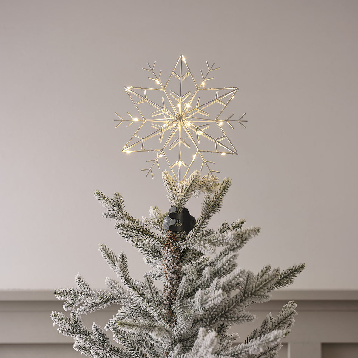 Nahaufnahme der weißen LED Metall Schneeflocke Weihnachtsbaumspitze mit warmweißen LEDs