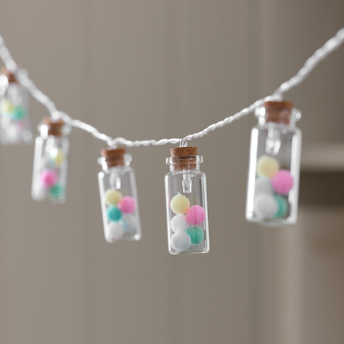 LED-Lichterkette mit Glasfläschchen gefüllt mit pastellfarbenen Pompoms, warmweißes Licht