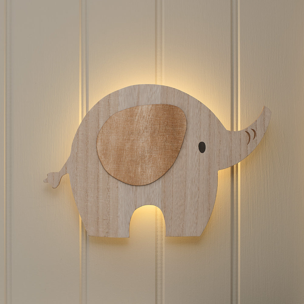 Holz-Wandlampe in Elefantenform mit warmweißem Licht hinter der Silhouette