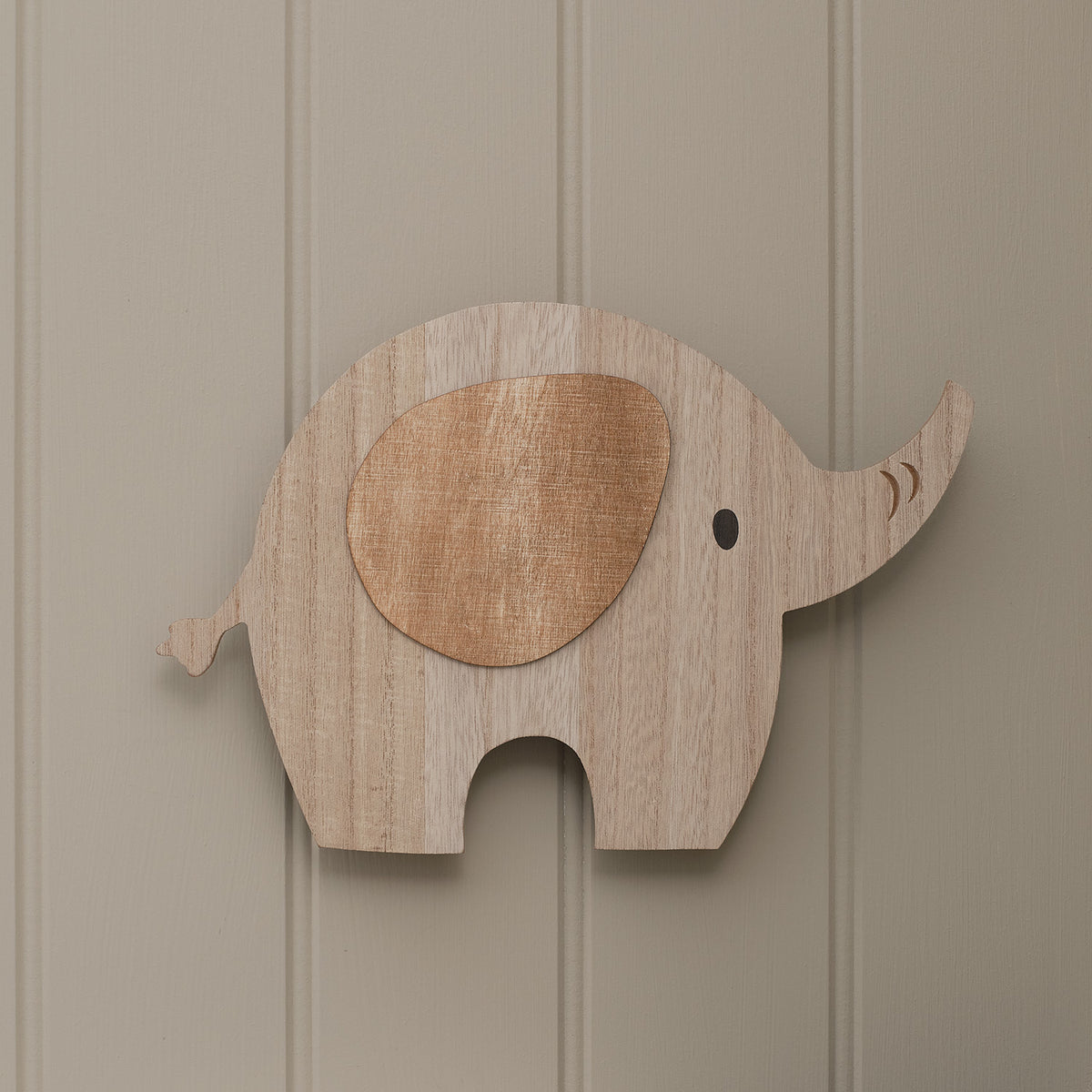Holz-Wandlampe in Form eines Elefanten ohne Licht an einer hellen Wand im Kinderzimmer