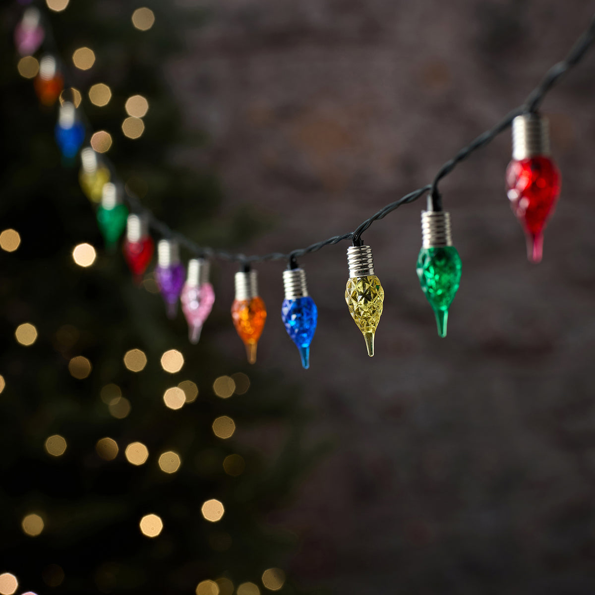 Bunte LED-Tropfen-Lichterkette mit farbigen Glastropfen vor unscharfem Hintergrund