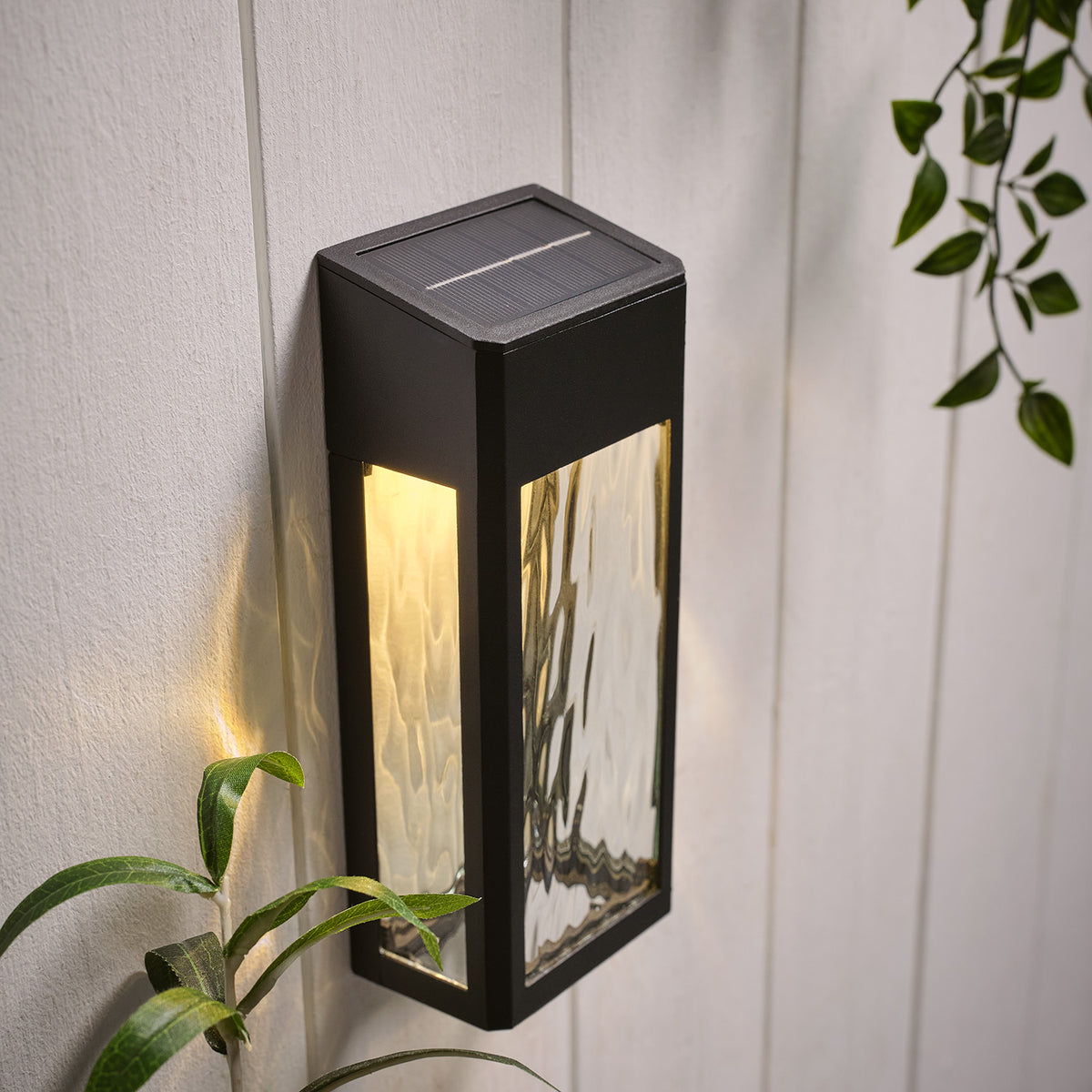 Solar-Wandleuchte mit warmweißem Licht und strukturierter Glasfront an weißer Wand