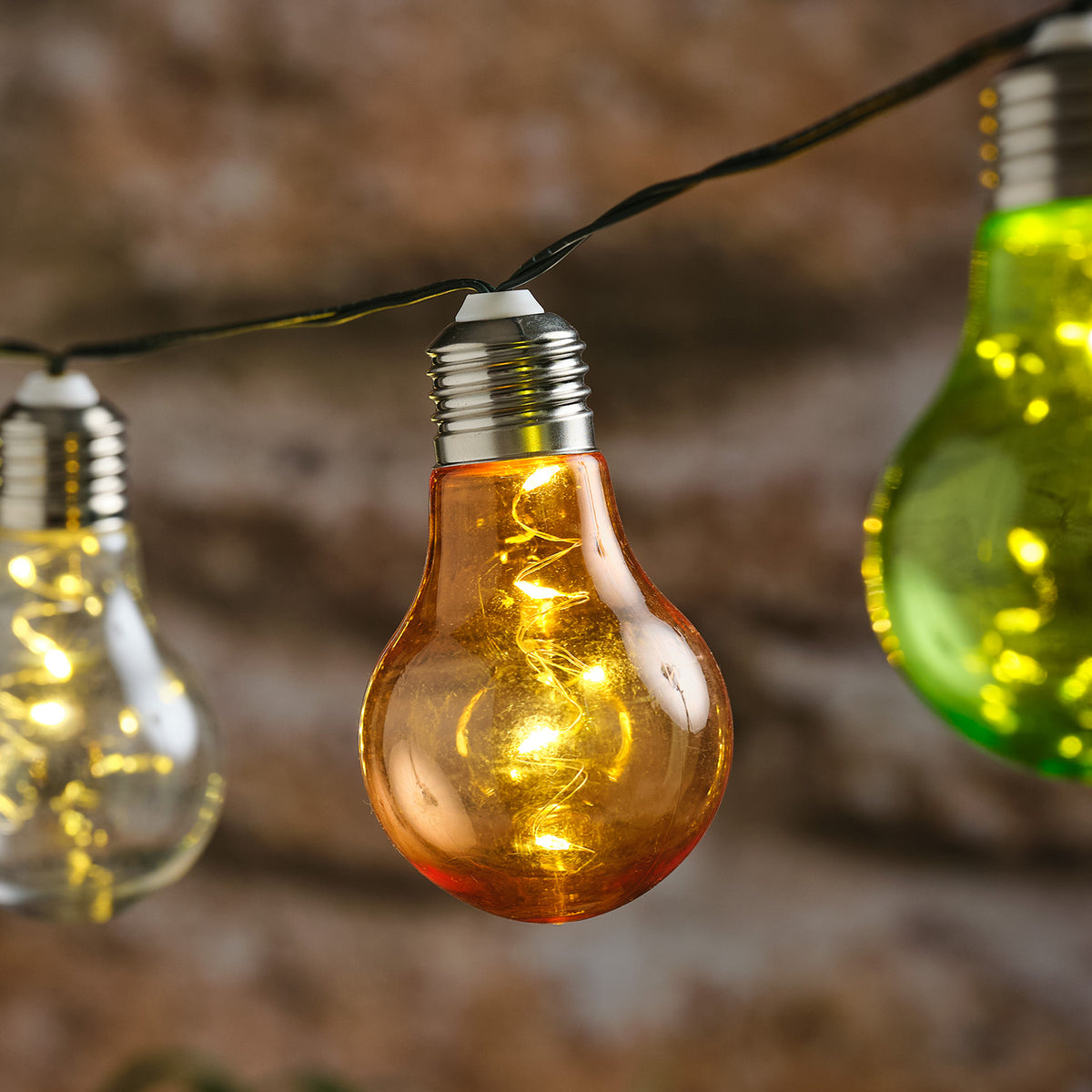 Detailansicht einer leuchtenden orangefarbenen Glühbirne mit spiralförmigen Mikro-LEDs