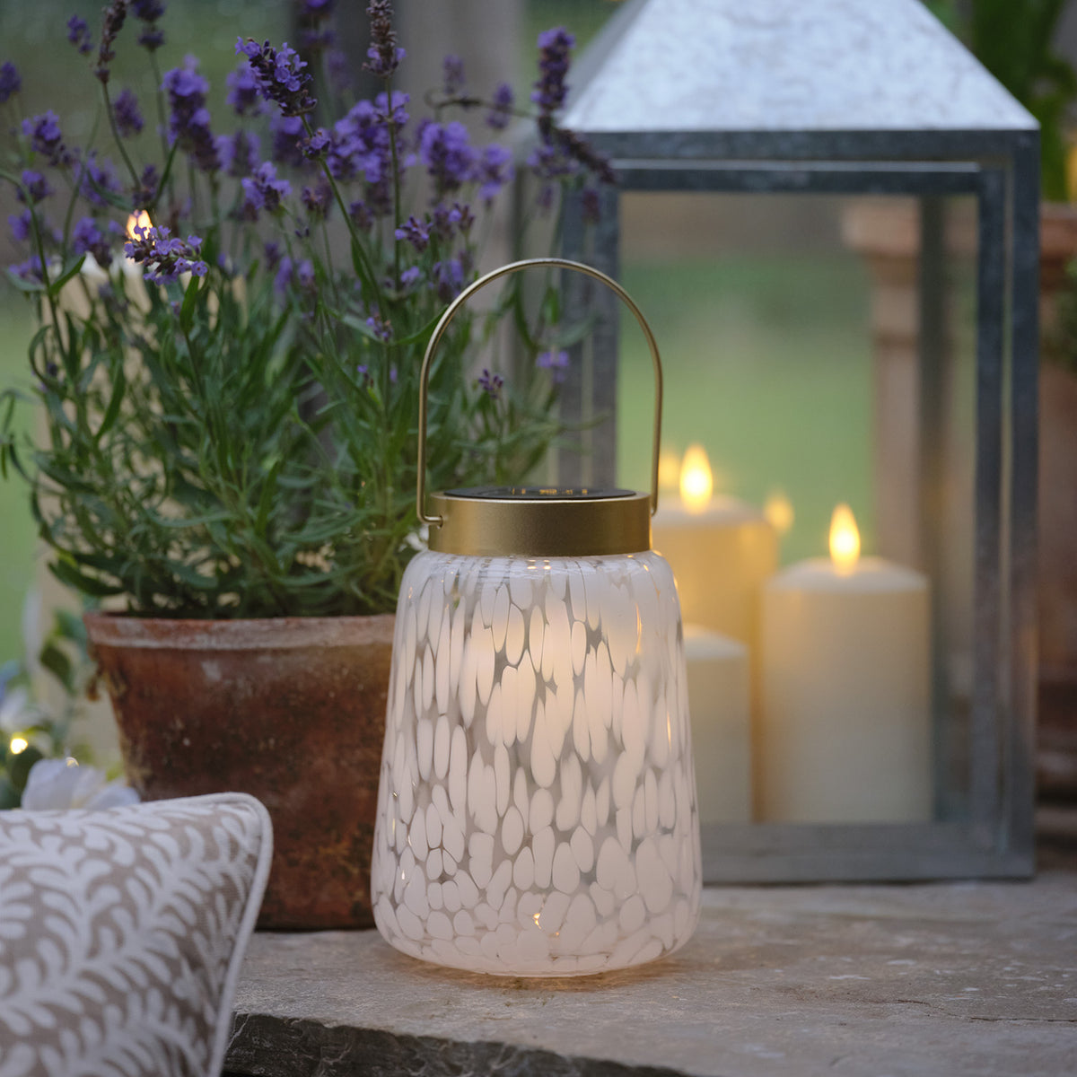 Nahaufnahme der Solarlaterne mit warmweiß leuchtender LED und goldfarbenem Henkel