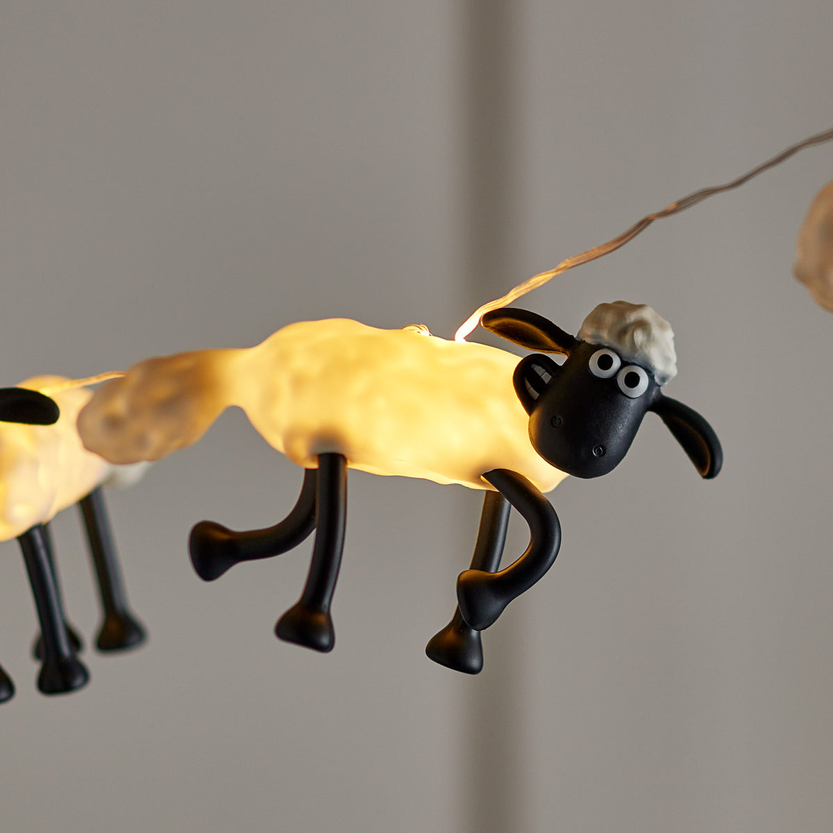 Leuchtende Shaun the Sheep Figur der Lichterkette mit schwarzem Kopf und weißen Augen