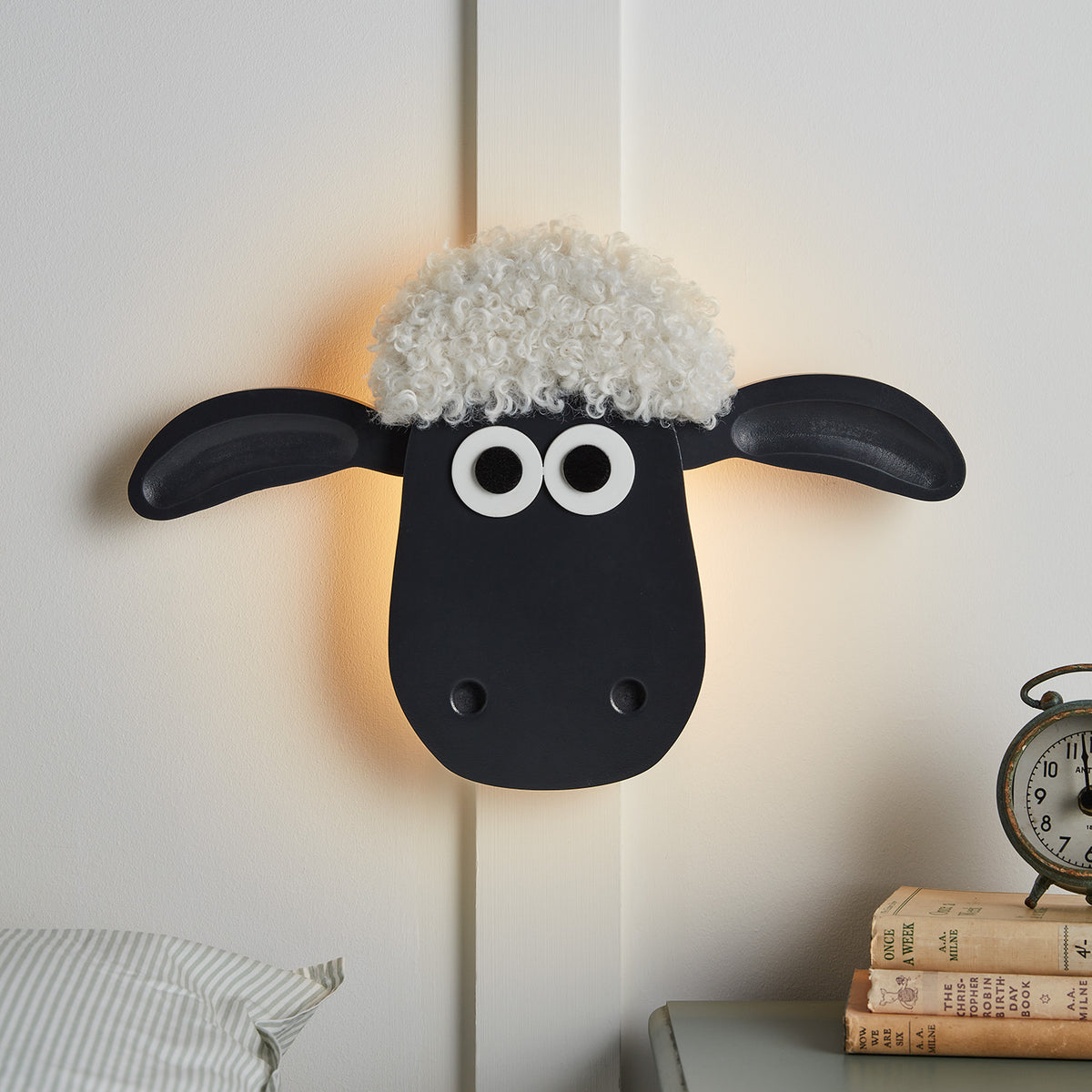 Shaun the Sheep Wandlampe mit schwarzem Gesicht und weißen Locken an weißer Wand