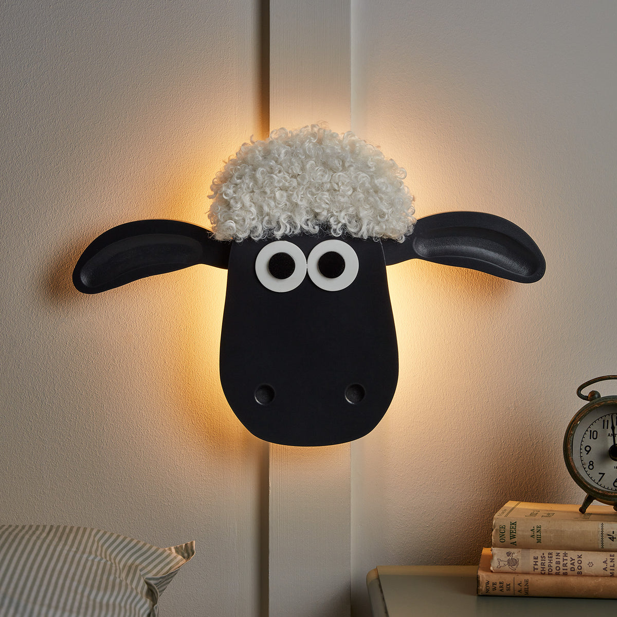 Beleuchtete Shaun the Sheep Wandlampe mit warmem Licht an weißer Wand