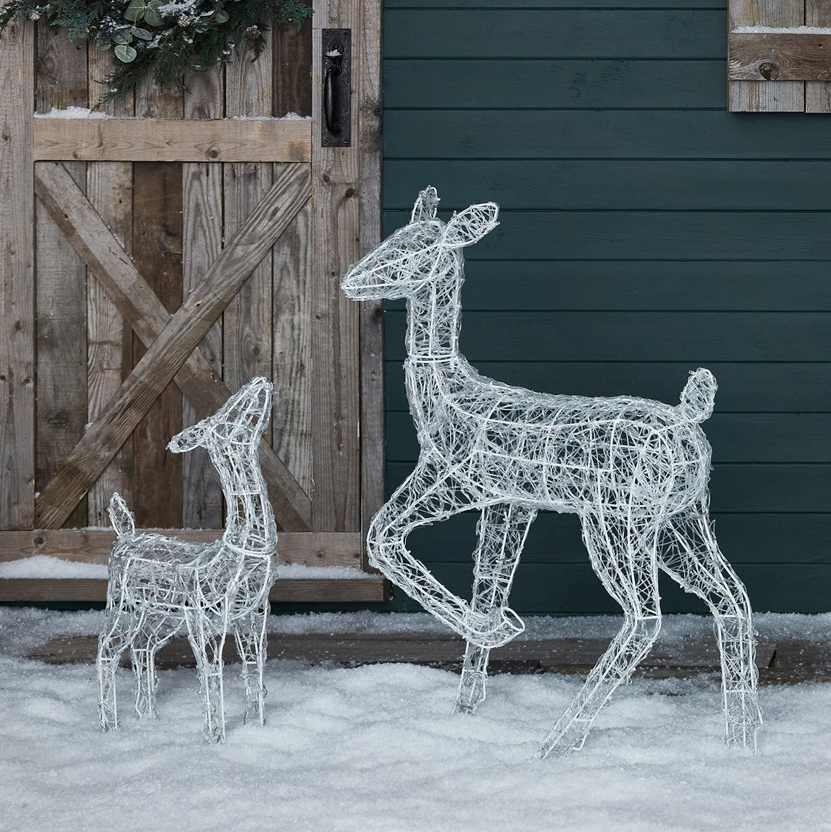 Leuchtende Acryl-Rentier Rehkitz im Wohnzimmer vor Fenster mit Weihnachtsbaum und Geschenken