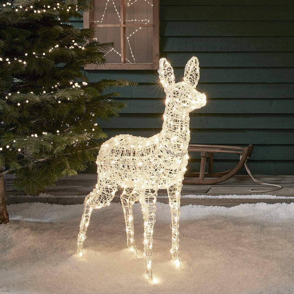 Bicolor LED Rentier Hirschkuh mit warmweißem Licht vor Hauswand und Tannenbaum