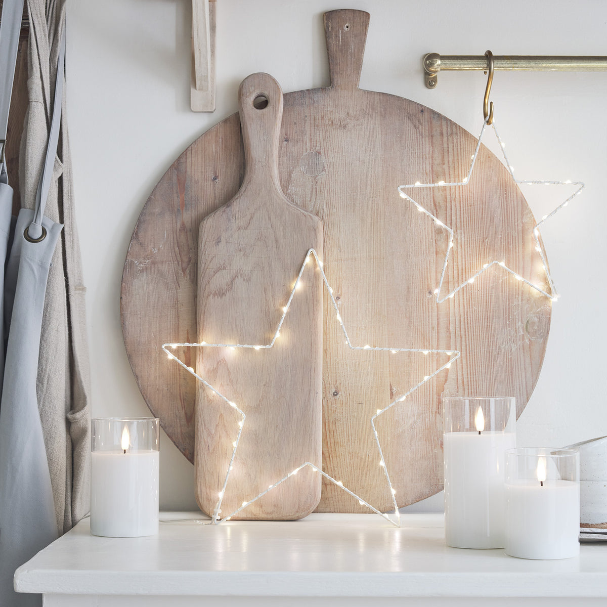 Großer und kleiner leuchtender LED-Stern mit Tannenzweigen und Weihnachtsdeko
