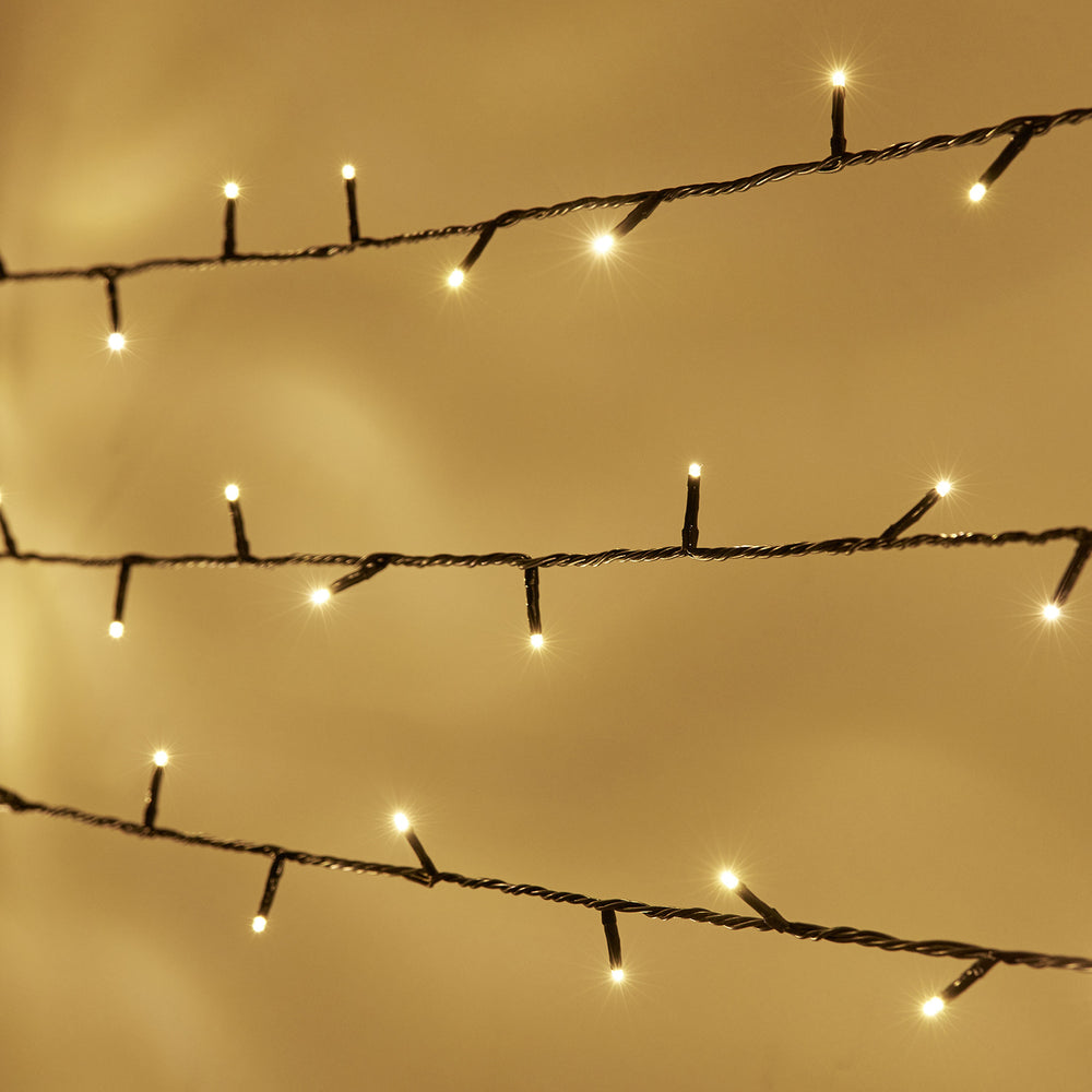 Nahaufnahme von warmweißen LED-Lichtern an grüner Kabel-Lichterkette