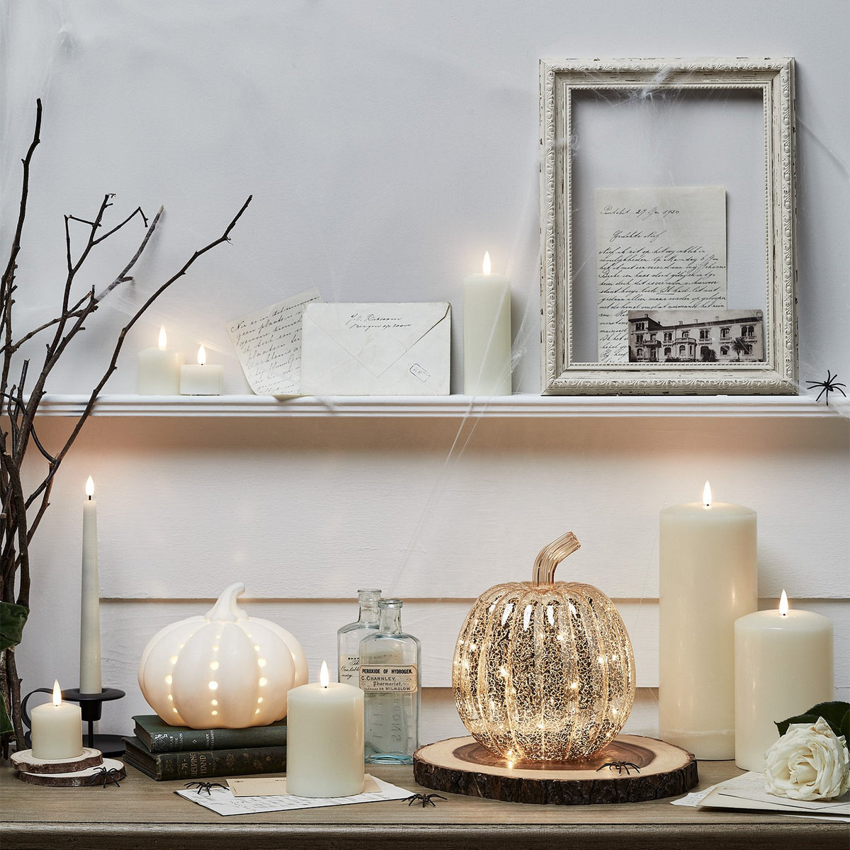 Antikgoldener LED Glas-Kürbis auf Holztisch mit Herbstdekoration und Lichterkette