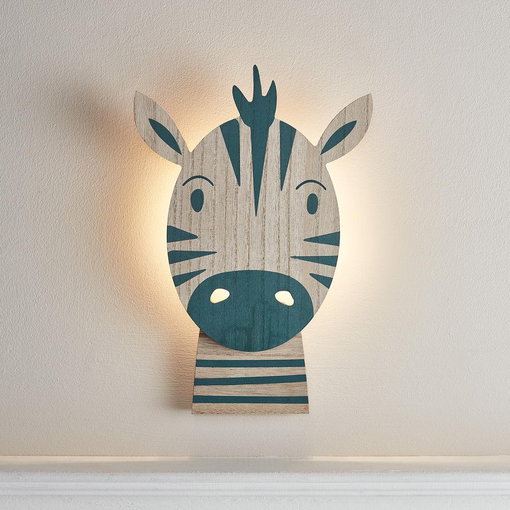 Beleuchtete Zebralampe aus Holz mit warmweißem LED-Licht an weißer Wand im Kinderzimmer
