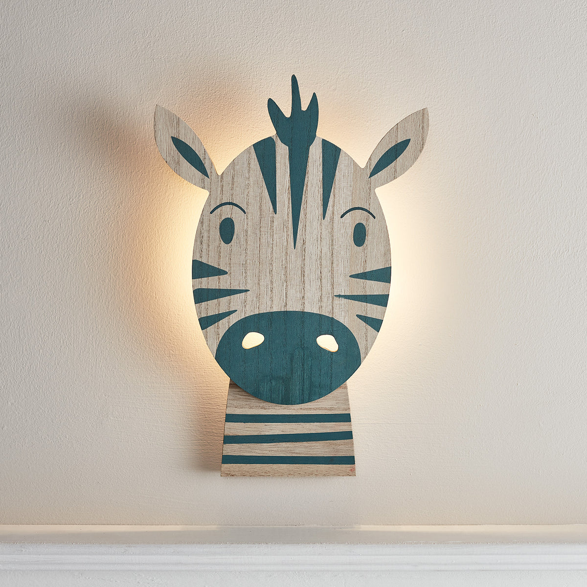 Beleuchtete Zebralampe aus Holz mit warmweißem LED-Licht an weißer Wand im Kinderzimmer