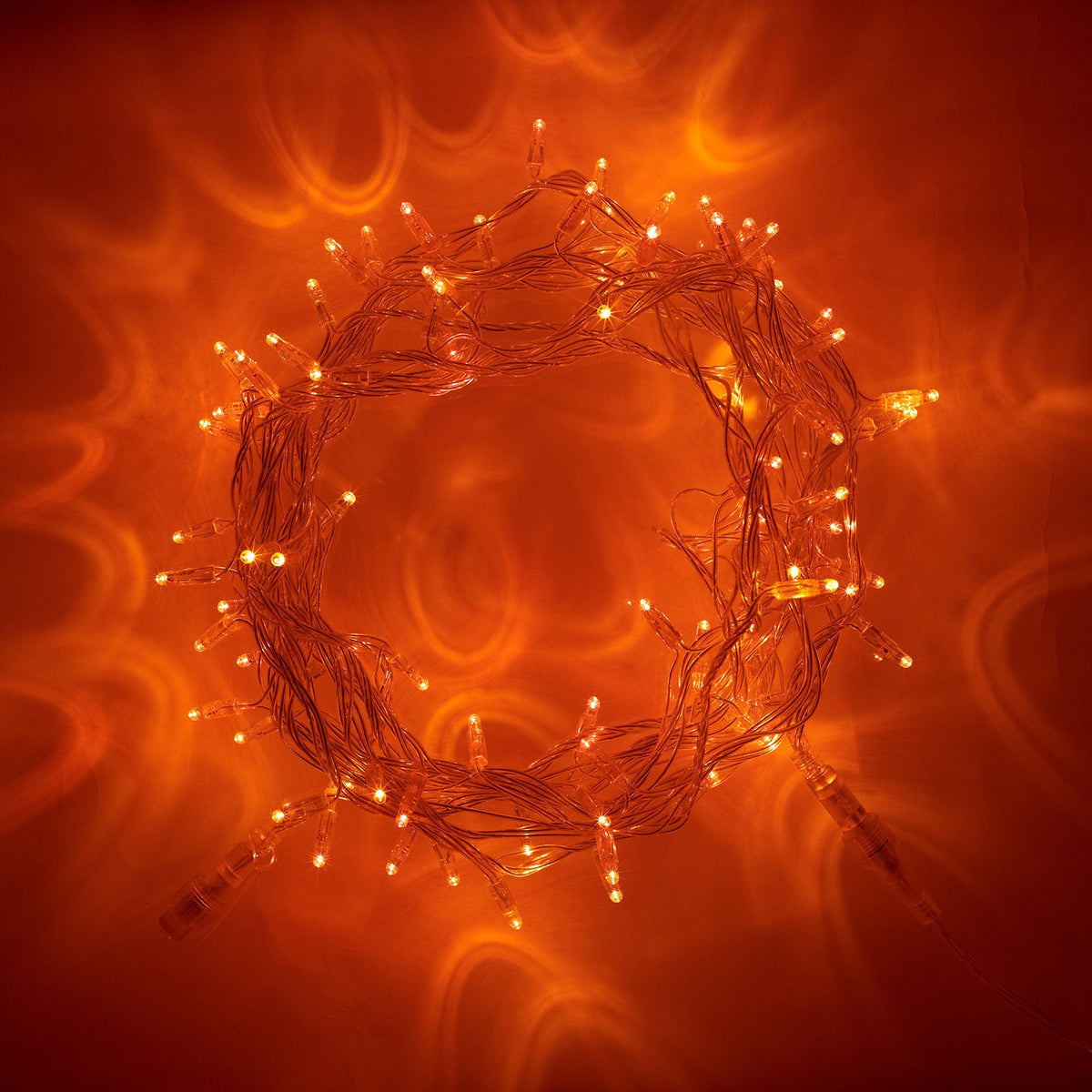 Nahaufnahme einer leuchtenden orangenen LED-Lichterkette mit transparentem Kabel