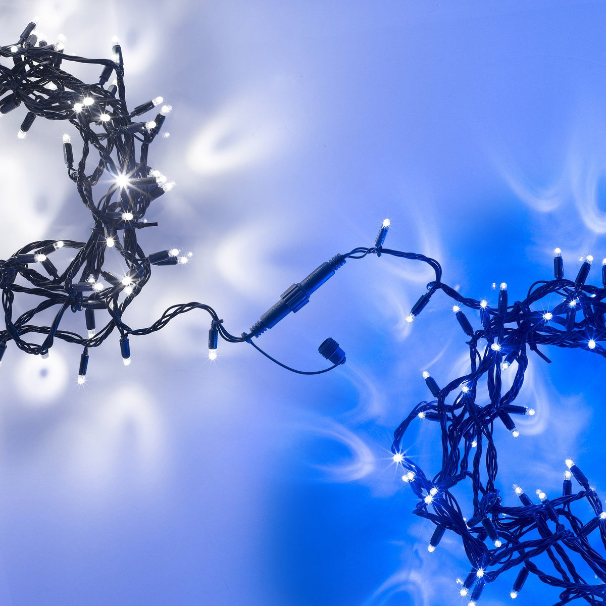 Lichterkette mit blauen LEDs und grünem Kabel mit Steckverbindung auf weiß-blauem Hintergrund