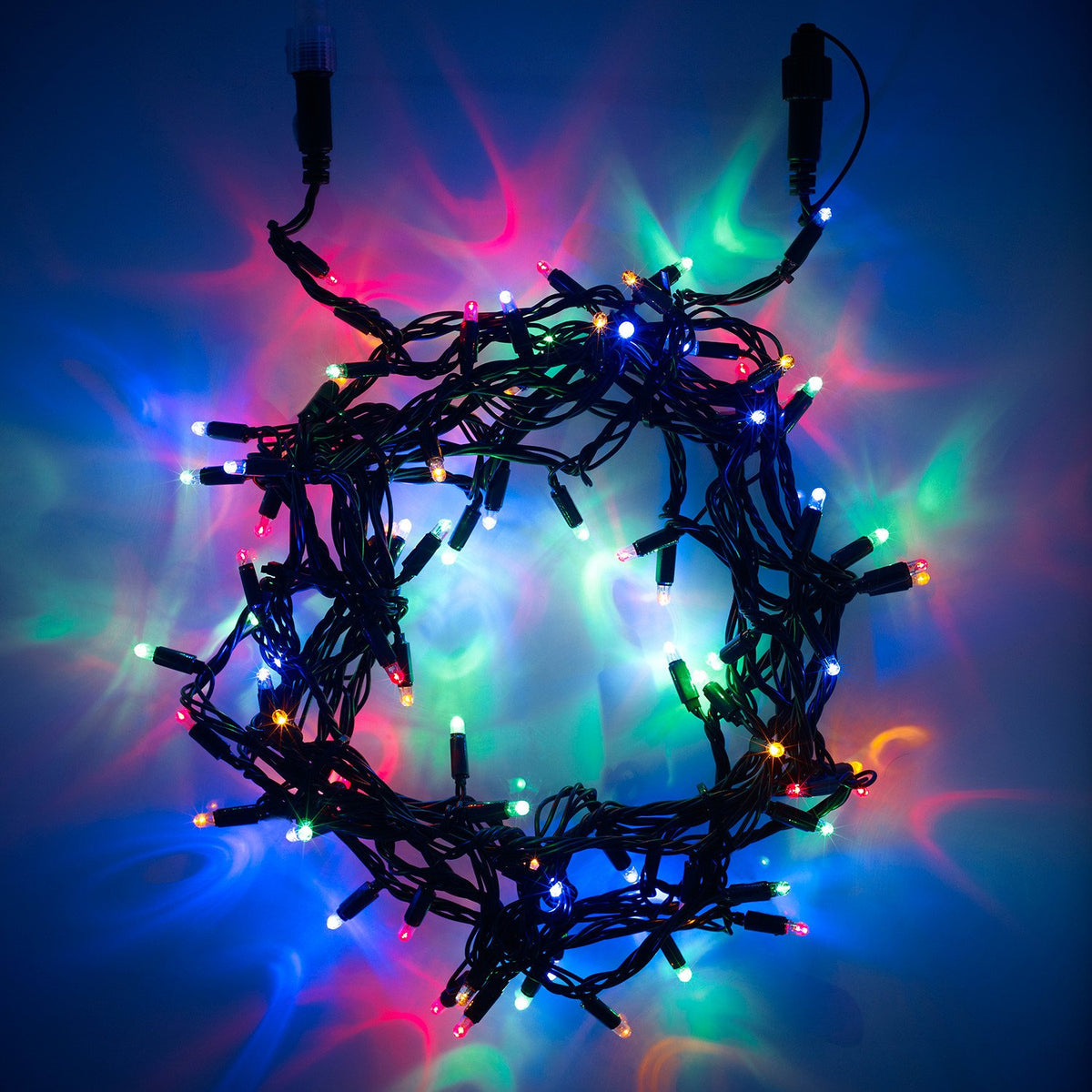 Bunte LED-Lichterkette mit grünem Kabel leuchtet in verschiedenen Farben auf dunklem Hintergrund