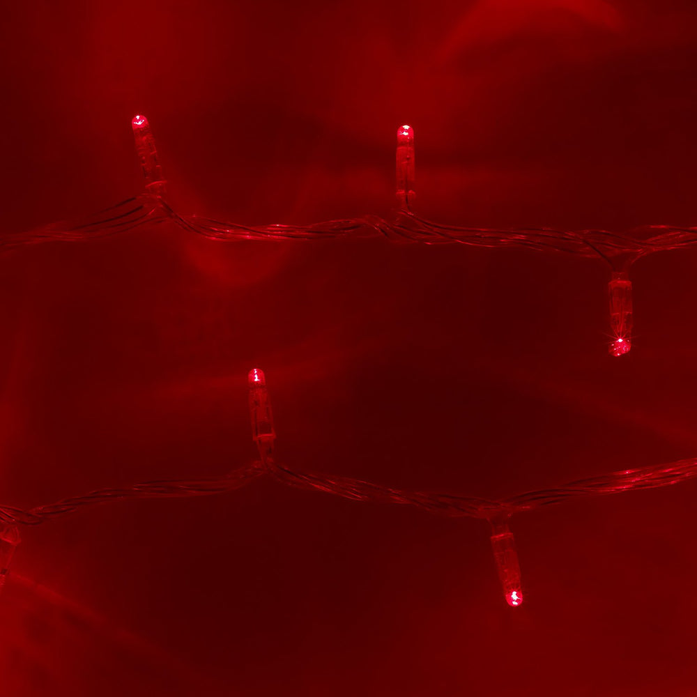 Nahaufnahme roter LED-Lichter an transparentem Kabel auf rotem Hintergrund