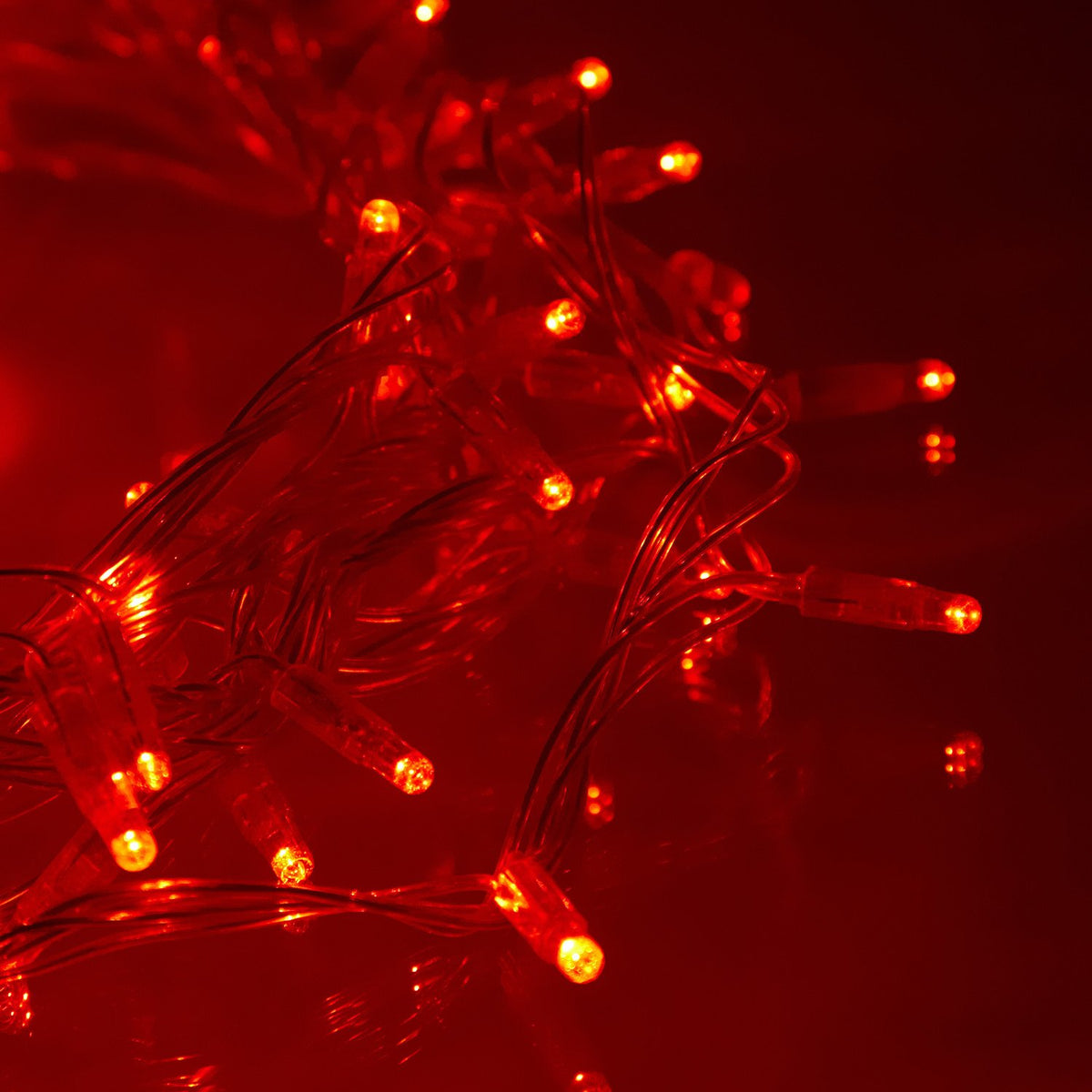 Detailaufnahme einer roten LED-Lichterkette mit transparentem Kabel im Dunkeln