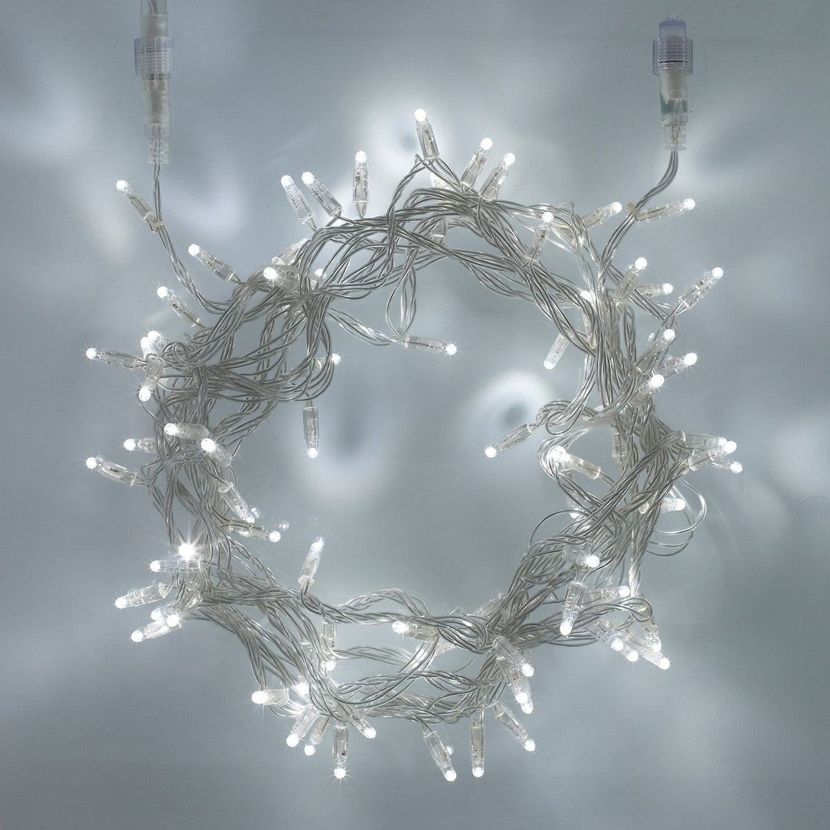 Weiße LED-Lichterkette mit transparentem Kabel in Kreisform auf hellem Hintergrund
