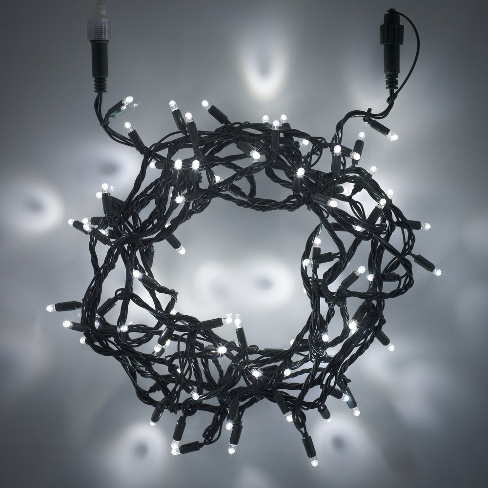 Weiße LED-Lichterkette mit grünem Kabel und Steckverbindung auf grauem Hintergrund