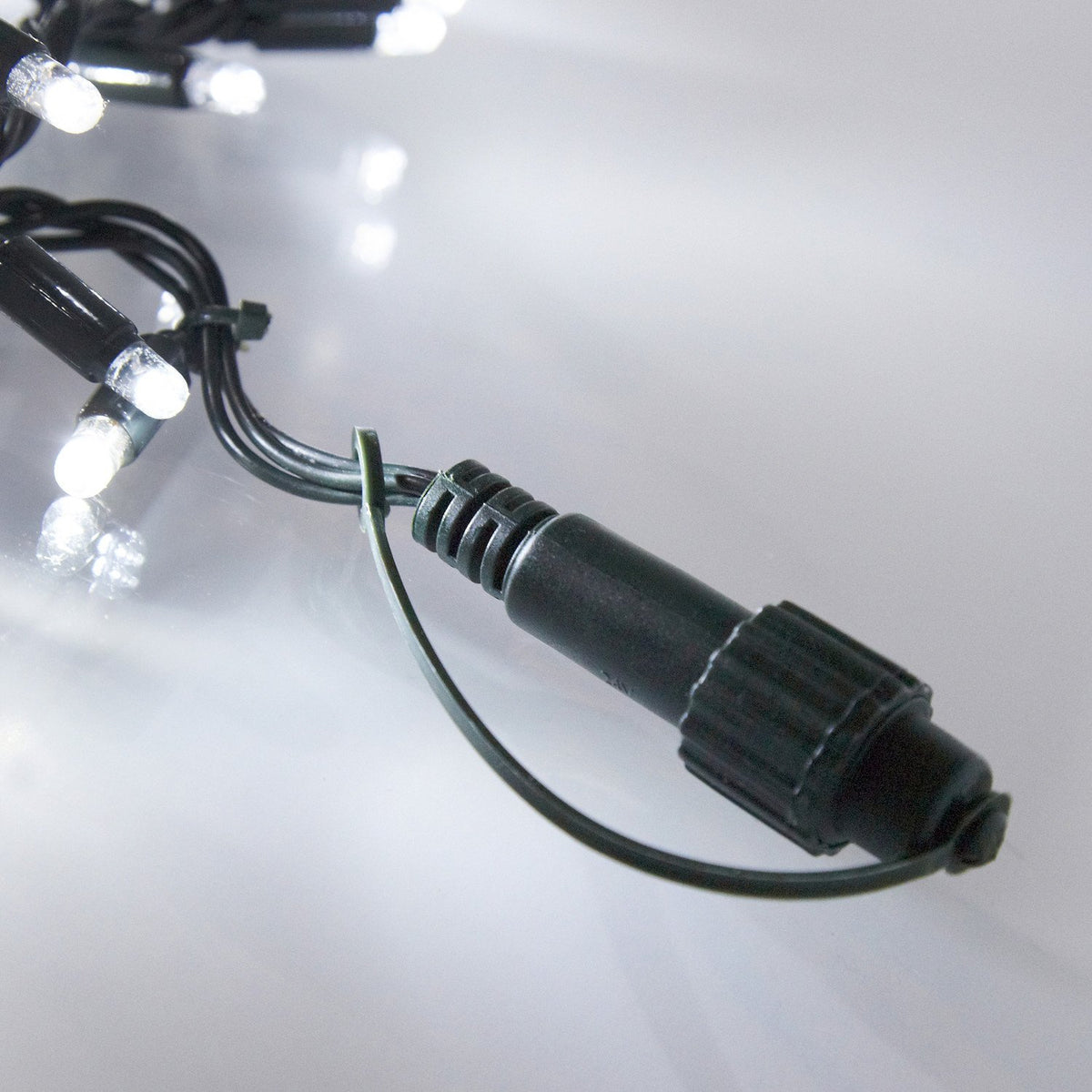 Nahaufnahme von weißen LED-Lichtern an grünem Kabel mit Steckverbindung