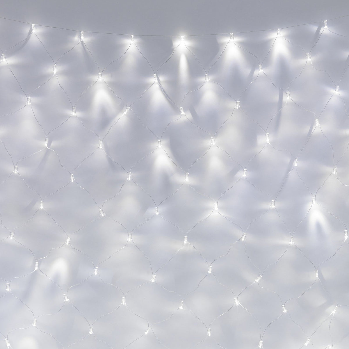 Weißes LED-Lichternetz mit transparentem Kabel vor weißer Wand in Nahaufnahme