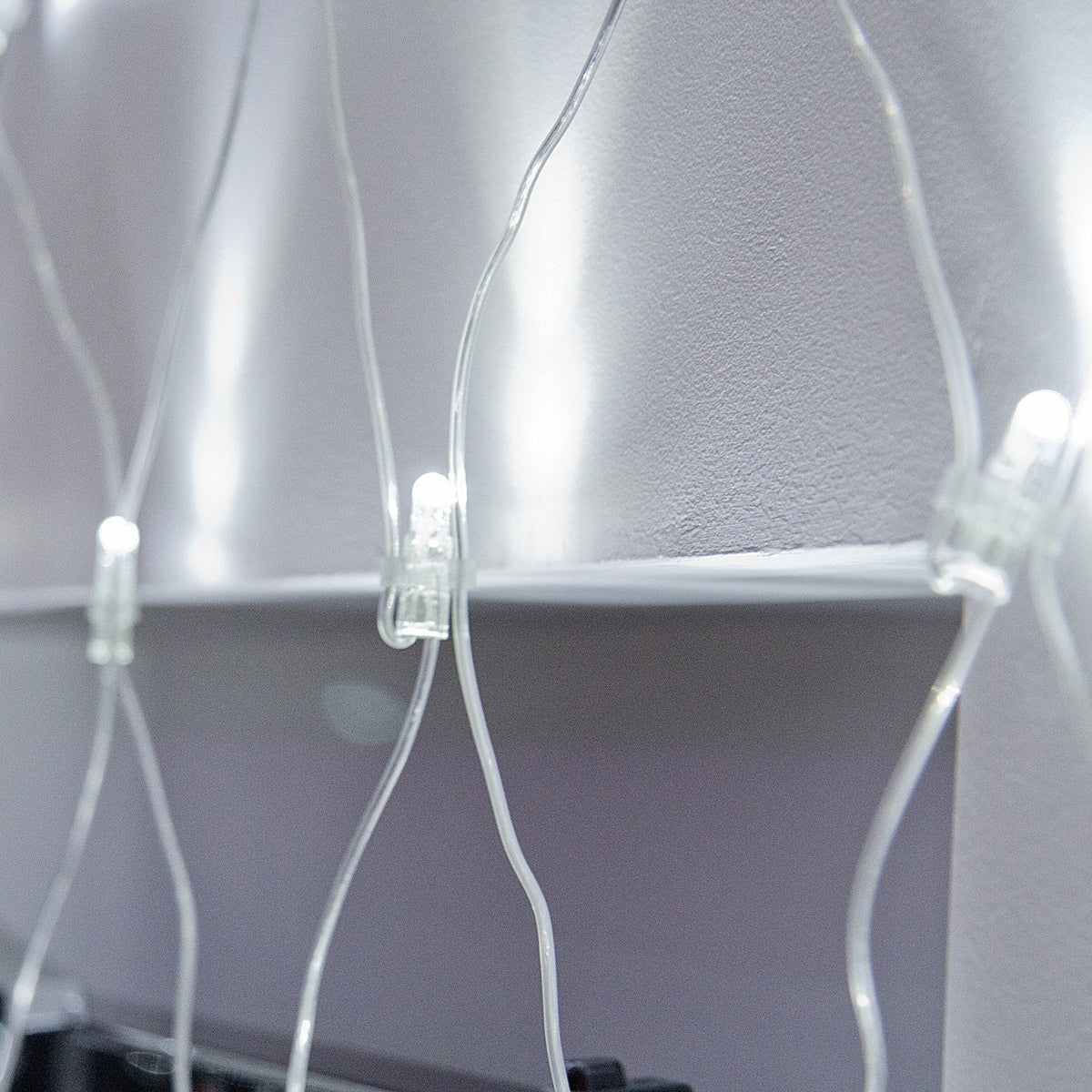 Nahaufnahme eines einzelnen weißen LED-Lichts im transparenten Lichternetz