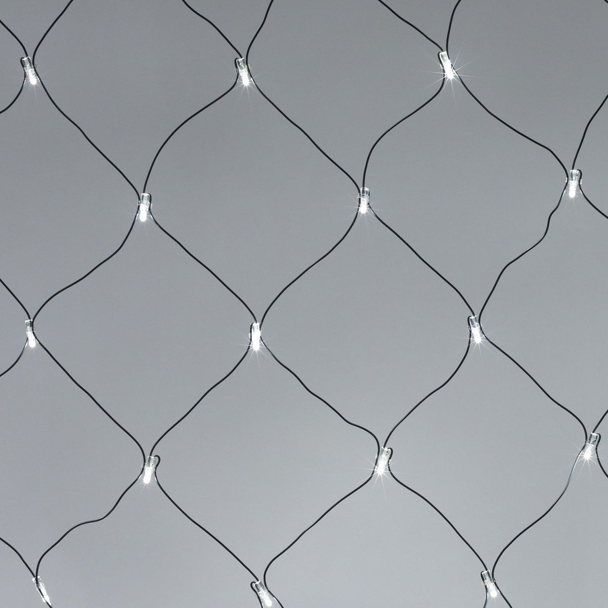 Detailaufnahme eines weißen LED-Lichternetzes mit grünem Kabel vor grauem Hintergrund